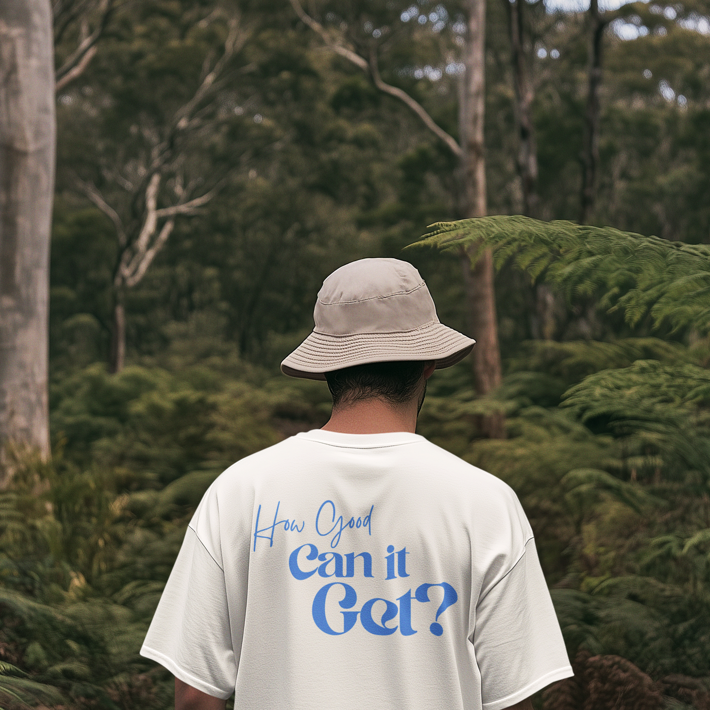 Person wearing a white t-shirt with text in a forest